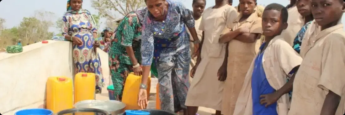 Children and an adult fetching water