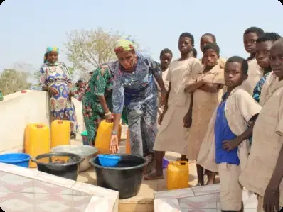 Children and an adult fetching water